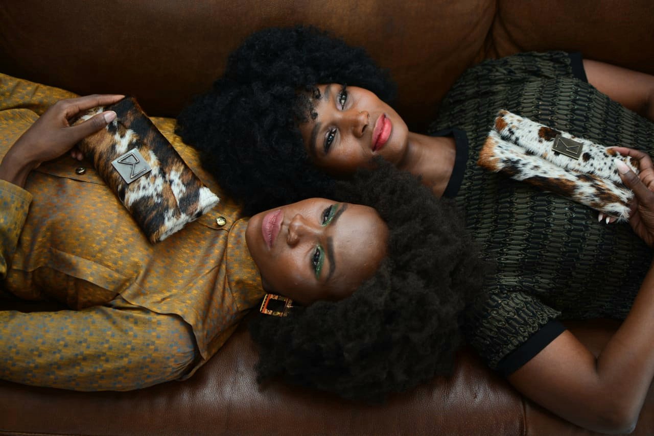 2 Mabotho models on a couch with handbags